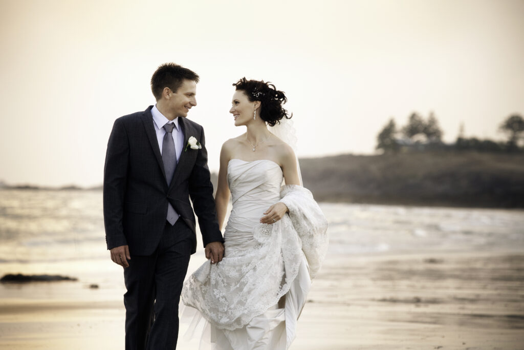 Editorial wedding portrait of a couple walking along the beach