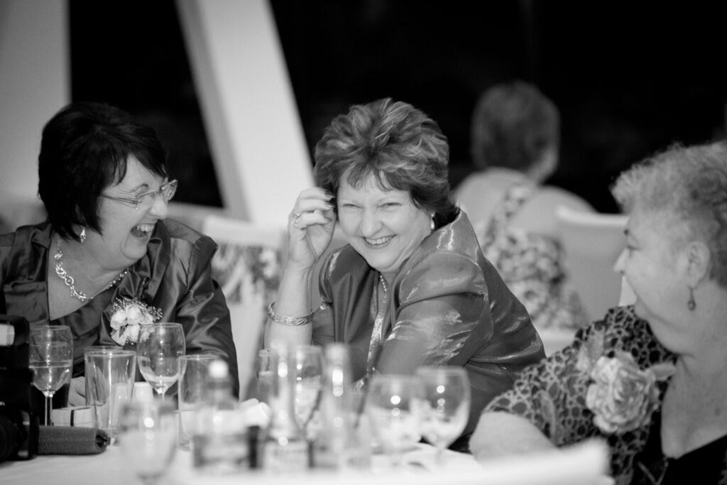 Wedding guests laughing together at the reception